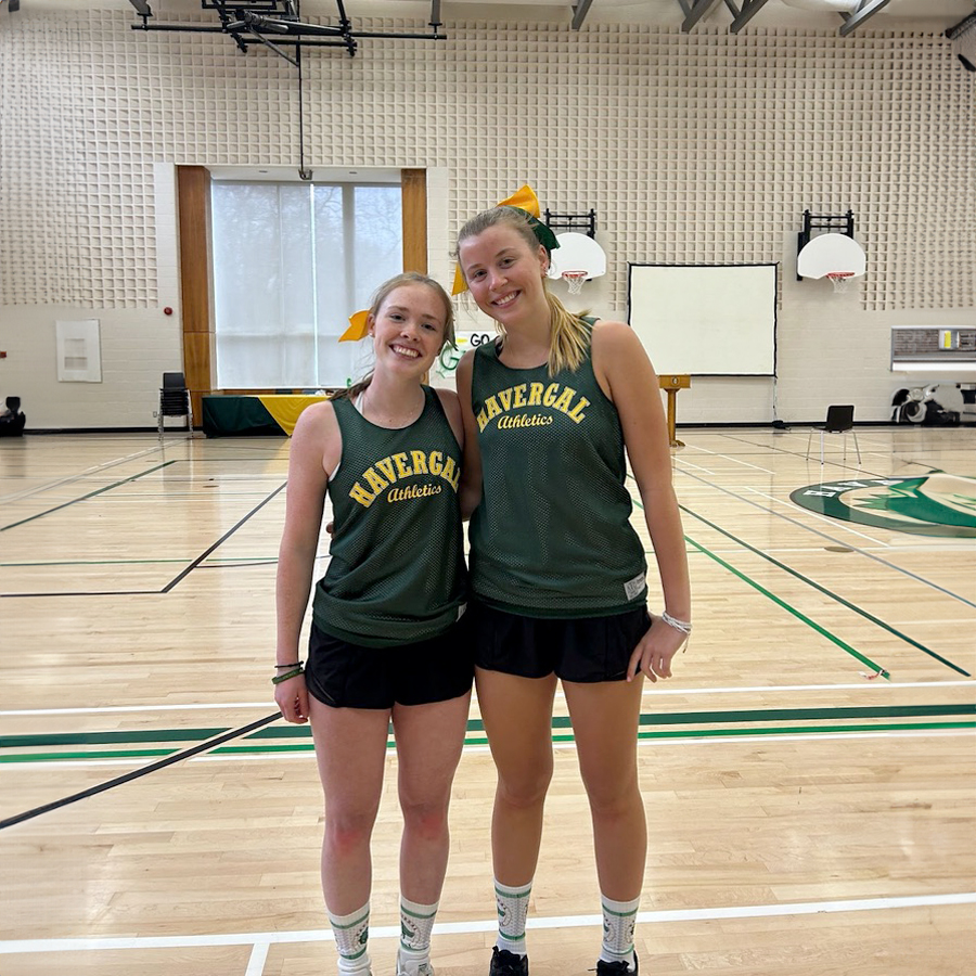 Paige and Kaitlyn standing together in the gym wearing Havergal Basketball Team outfits.